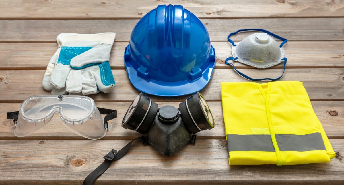 Work safety protection equipment on wooden background.